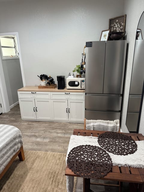 Kitchenette with microwave, air fryer, utensils, plates, and 2 burner cooktop.