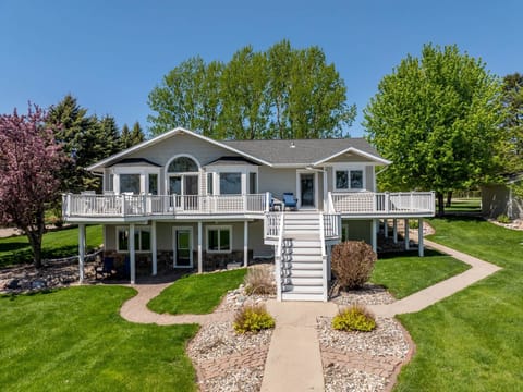 Lakeside house view with large yard and wrap around deck