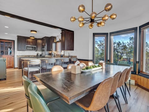 Gather for unforgettable meals at the stylish dining table with panoramic mountain views and an open-concept gourmet kitchen just steps away.