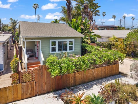 Charming coastal cottage retreat, framed by lush greenery and sunshine.