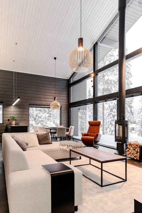 The open-plan living area is the heart of the home. It includes a modern lounge with large sofas, a flat-screen TV, and beautiful views of the surrounding nature. The stylish Nordic interior blends wood, light, and space to create a calming atmosphere – p