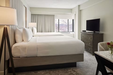 Unwind in plush beds with bright, calming window light.