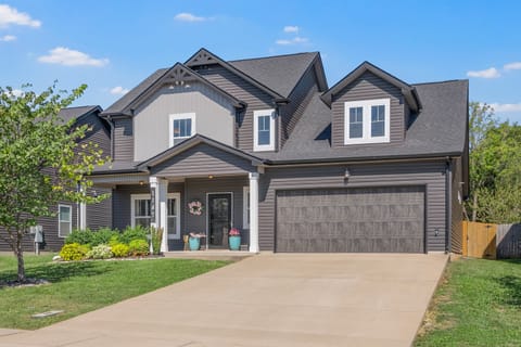 Full front view of home with covered porch and two car garage