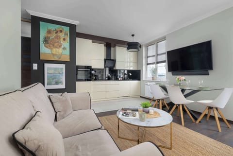 The bright living room with a comfortable sofa and wall-mounted TV invites you to relax after a busy day, while the open space creates a pleasant atmosphere for gatherings.