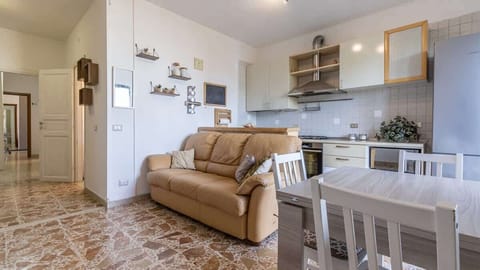 panoramica zona giorno condiviso con soggiorno, tavolo pranzo e cucina completamente attrezzata