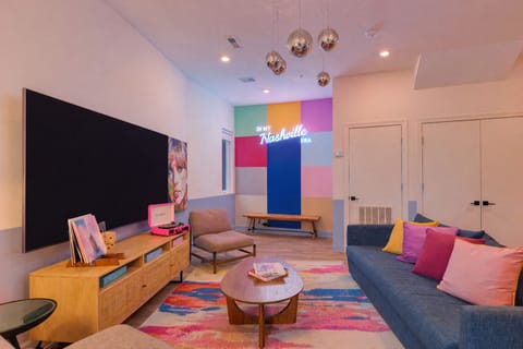 Living room with flat-screen TV and colorful design.