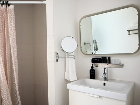 Bathroom with toilet, shower, and sink.