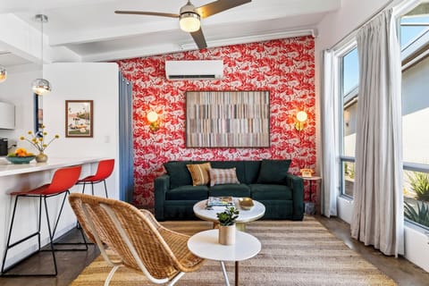 Bold flamingo wallpaper brings playful personality to this bright living area, with cozy seating and a breakfast bar just steps away.