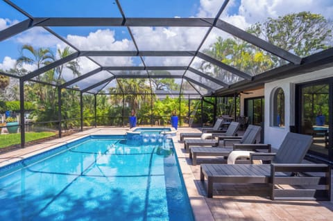 Dive into your private, screened-in pool and spa, your tropical oasis awaits! Enjoy the sun on a lounge chair surrounded by lush greenery.