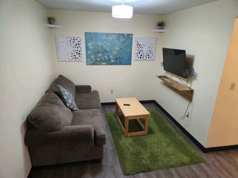 Comfortable living room with plush sofa, wall-mounted TV, and decorative accents