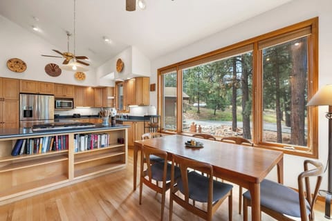 One of two dining areas in the home, set beside large windows overlooking the pines — a bright and inviting spot for shared meals, morning coffee, or planning the day’s adventures.