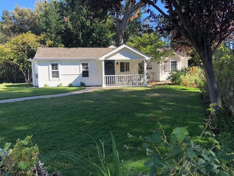 This charming freestanding home offers a peaceful, private stay with no shared walls - perfect for guests looking for quiet and comfort. It is surrounded by a spacious green yard and mature trees, and features a welcoming front porch.