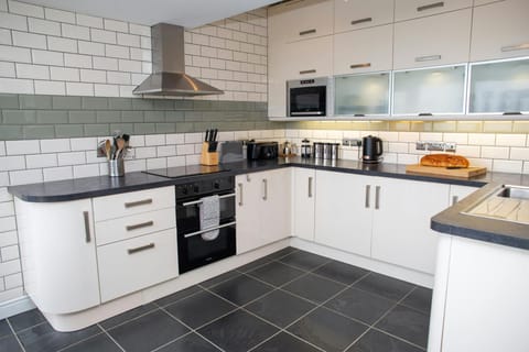 Kitchen with microwave, electric hob, oven and extractor hood