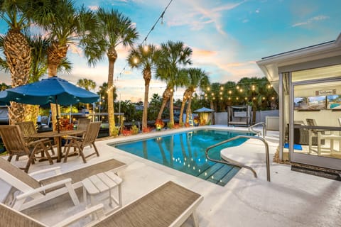 Bistro lights glow above the water as palm trees light up your private paradise.