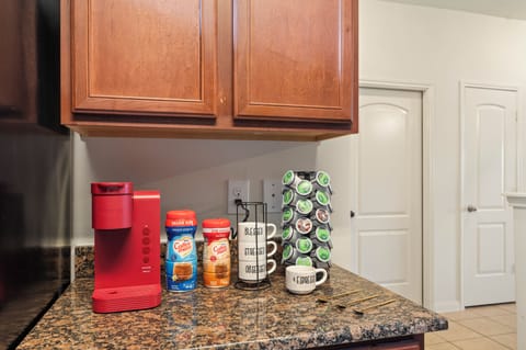 Coffee station with pods, creamer, sugar, and mugs ready to enjoy