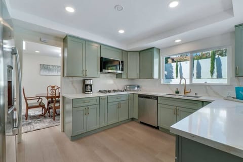 Fully stocked kitchen with stainless steel appliances and 12-cup drip coffee maker.