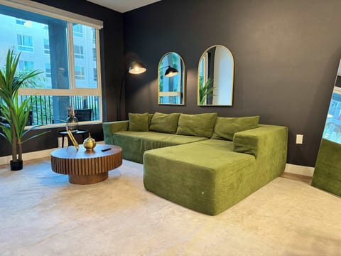 Spacious living room featuring a cozy L-shaped sofa, a full-size air mattress, and a 65" Smart TV with preloaded access to Netflix, Hulu, and Disney+, all set up for your enjoyment.