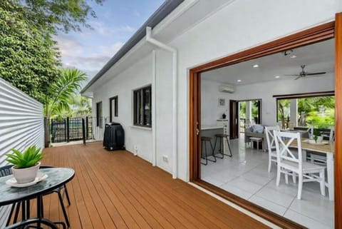 Covered outdoor deck with dining area and seamless indoor–outdoor living.