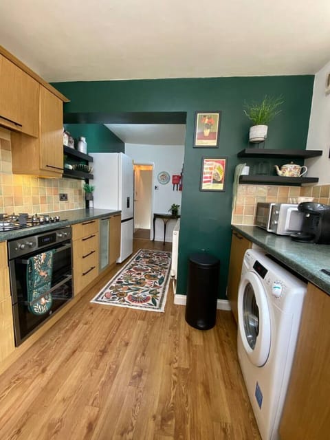 Fully equipped kitchen with modern appliances and warm green tones