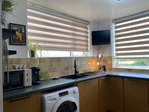 Bright kitchen with washer, oven, and countryside views
