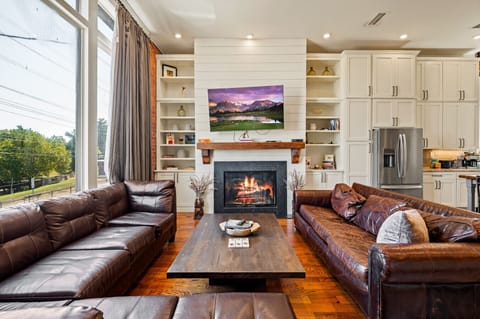 Living Room| Bright open-concept space with leather seating, cozy fireplace, and smart TV