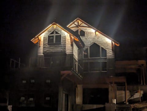 Exterior up-lighting showcases the beautiful timberframe construction and slate