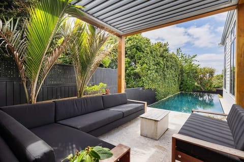 Swimming pool with poolside lounge seating and louvre-tech shelter for all year round enjoyment