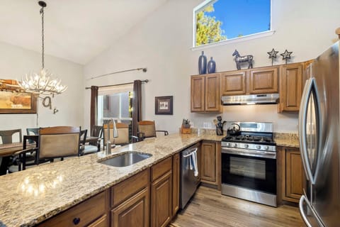 Fully equipped galley kitchen with stainless steel appliances, granite countertops and open to living room and dining.