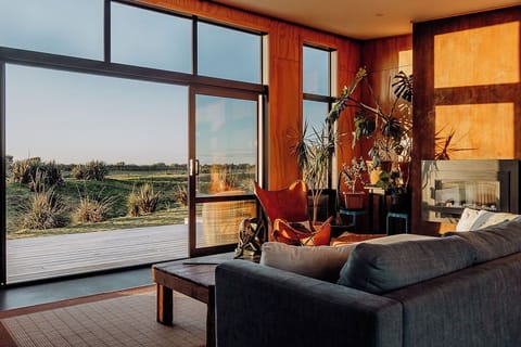 A lounge filled with sea views and soft, natural tones
