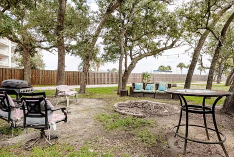 Relax under the trees with firepit seating, string lights, and a BBQ area