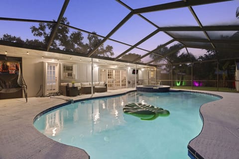 Enjoy a screened-in pool, soothing hot tub, and cozy lounge area