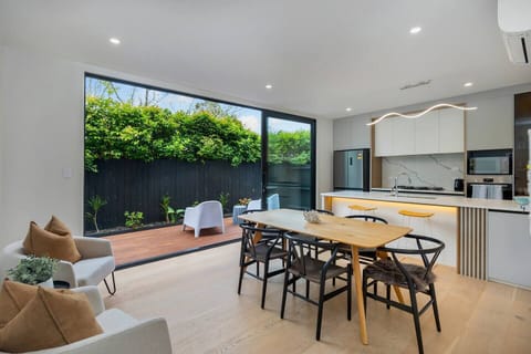 Open plan kitchen and dining, with lounge seating and sliding doors opening out to a deck and patio. Heated and cooled with Air-conditioning.