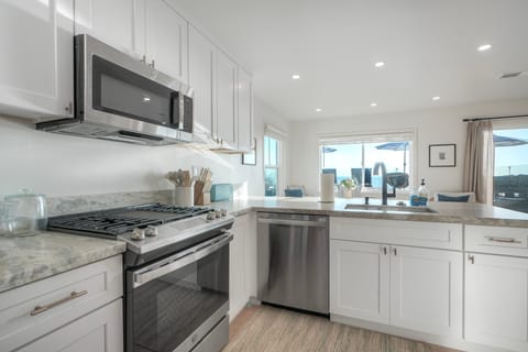 Modern kitchen with ocean views and sunlight.