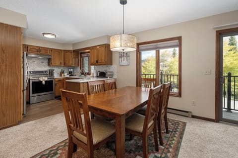 Your well-equipped kitchen flows seamlessly into the dining space, where warm wood tones and natural light create the perfect gathering spot for family meals.