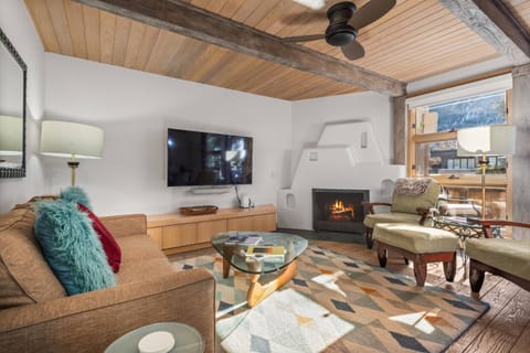 This cozy living room with fireplace and tv overlooks Aspen mountain