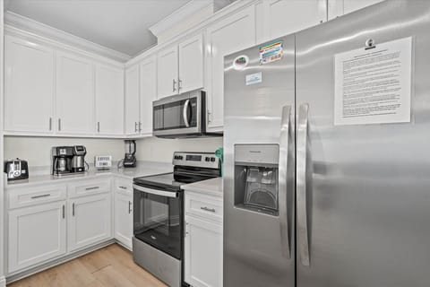 Your fully equipped kitchen features stainless steel appliances and crisp white cabinets, perfect for preparing meals during your stay.