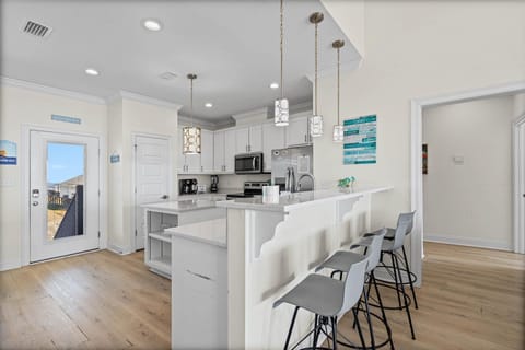 Your bright modern kitchen features sleek white cabinets, granite counters, and bar seating perfect for morning coffee or casual meals together.