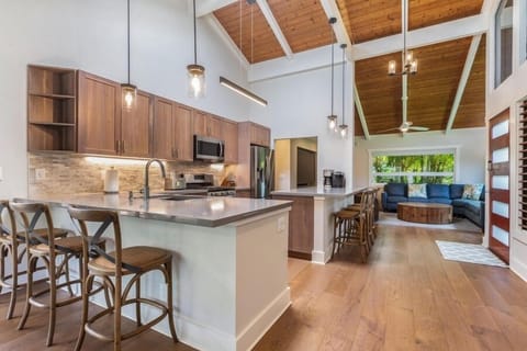 Lani Oasis’ chef-ready kitchen includes stainless steel appliances, a large island with bar seating, and open flow to dining and living spaces.