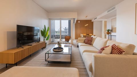 Relax in a chic, light-filled living room with designer touches and direct access to a private balcony. #MidCenturyVibes #OpenSpaceLiving #ModernStay