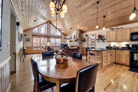 Open layout with living room, stone fireplace, and dining area at Dream Weaver cabin near Cherokee.