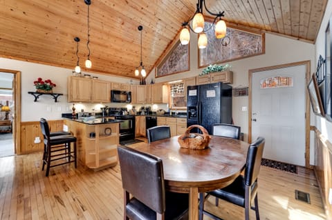 Cozy living room with vaulted wood ceilings, large windows, and stone fireplace at Dream Weaver cabin in Bryson City.