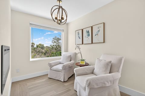 Seating nook with electronic fireplace and a window with a lovely nature view