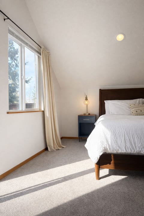 King Bedroom upstairs with West-facing windows and sliding glass door to balcony