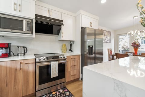 Modern kitchen with high-end appliances, espresso maker, and cooking essentials