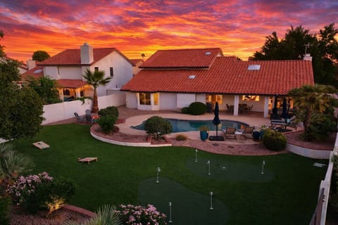 Outdoor oasis featuring a sparkling, heated optional pool, lounge chairs, outdoor dining table, BBQ grill, outdoor lounge areas, fire pit, putting green, bocce ball, & cornhole.
