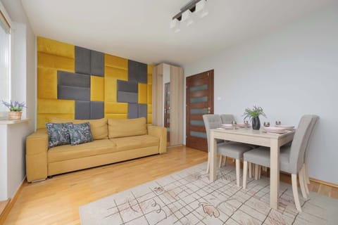 A cozy living area with wooden flooring, a soft rug, and colorful geometric wall art adding a modern touch.