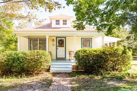 Charming Beaufort cottage with welcoming front porch, lush greenery, and walkable location