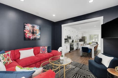 Cozy lounge with bold accent wall and red sofa.