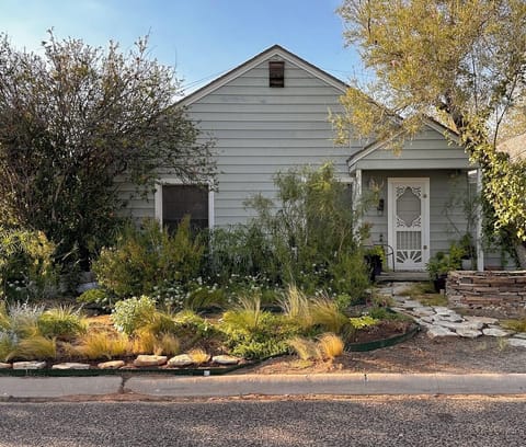 Cottage front porch, garden, and space for parking.