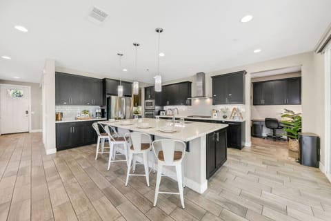 Fully equipped kitchen featuring island seating, double oven, and full-size refrigerator — ideal for group stays